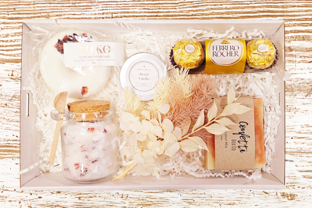 Soak and Relax Box 2: The ultimate relaxation gift featuring Lavender and Rose Bath Salts, a fun Donut Bath Bomb, Ferrero Rocher Chocolates, Coconut Milk Soap, Vanilla Lip Balm, and Dried Flowers. A perfect blend of soothing scents and indulgent treats for a serene experience.