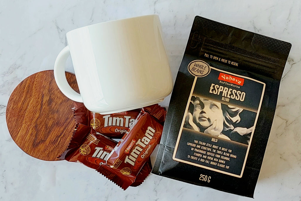 Bold Coffee Lover's Gift: A perfect package for coffee enthusiasts. Includes a 440ml Maxwell Williams white mug, 250g Yahava Koffee Works Espresso Whole Beans, three single-serve Tim Tams, and a wooden drink coaster. Ideal for espresso and stovetop brewing.